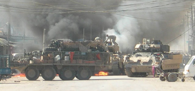 After being struck by an improvised explosive device in Baqubah, Iraq, a Bradley Fighting Vehicle immediately caught fire with its occupants still inside. Then-Spc. Christopher B. Waiters attempts to climb into the burning vehicle to rescue a trapped Soldier. Waiters had previously treated and evacuated two other casualties back to his Stryker. (Photo courtesy of the U.S. Army)