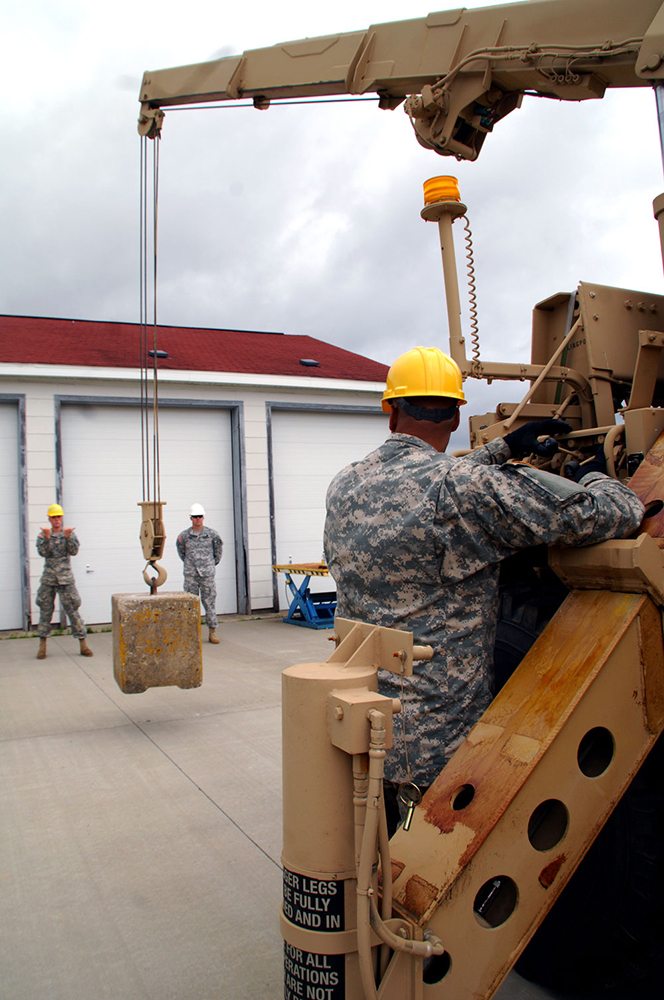 Sgt. Robert Reyes, right, maneuvers a concrete block as he learns the controls of a HEMTT wrecker at Fort McCoy, Wis. (Photos by Jonathan (Jay) Koester, NCO Journal)