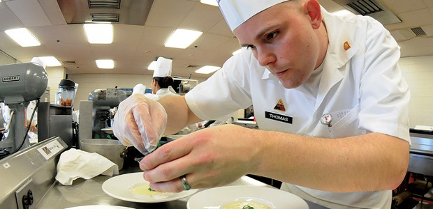 Military Culinary chef preparing a dish.