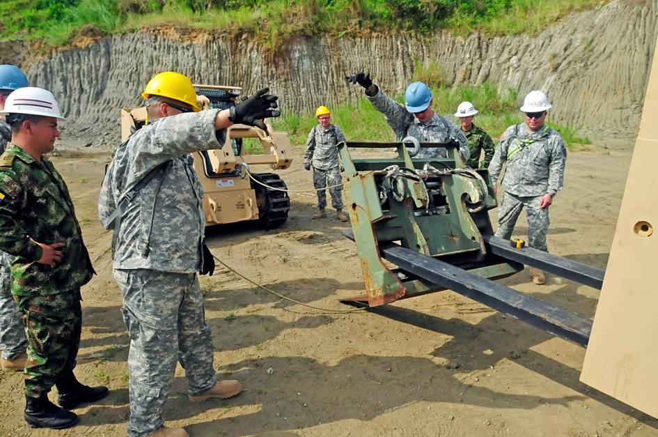 Staff Sgt. Jesus Rivera-Garcia (far right), a worksite safety noncommissioned officer with the 284th Engineer Company, 961st Engineer Battalion, 420th Engineer Brigade, U.S. Army Reserve, inspects a forklift load as members of the unit begin the process of unloading supplies to build a bathroom for a school during the U.S. Army South-organized Beyond the Horizon exercise in April 2013 at Achiote, Panama. (Photo by Sgt. 1st Class Walter van Ochten)