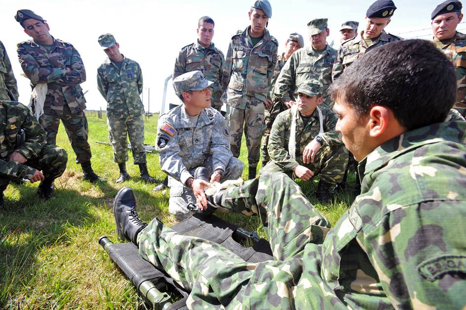Staff Sgt. Robert Hogeland (center), the clinical operations NCO in charge at U.S. Army South’s medical directorate, demonstrates various ways to stabilize a fractured ankle to members of the Uruguayan military during a tactical Combat Lifesaver Course subject-matter expert exchange in September 2014 outside of Montevideo, Uruguay. (Photo by Robert Ramon)