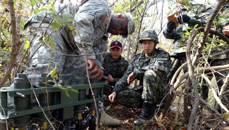 >Sgt. 1st Class Omar Jackson, <i>left</i>, a trainer with the Asia Pacific Counter-IED Fusion Center, demonstrates the Improvised Explosive Device Effects Simulator (IEDES) to Republic of Korea