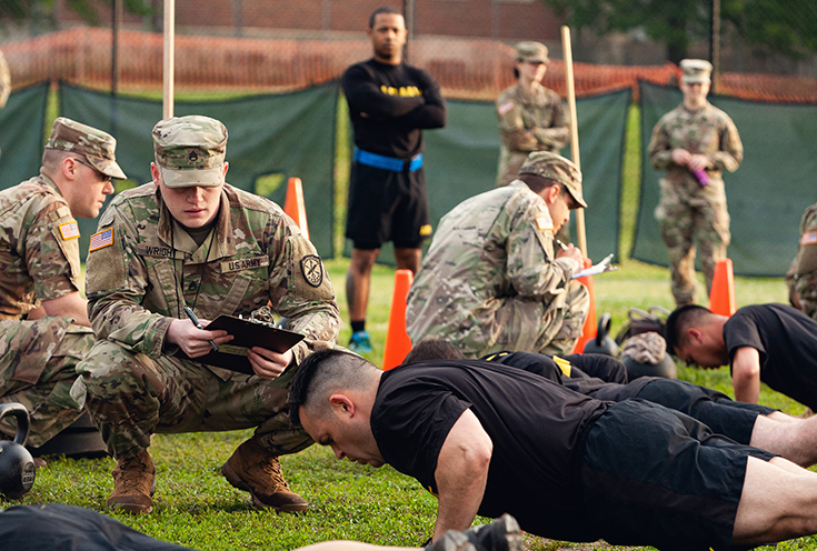 U.S. Army Staff Sgt. Gabriel Wright, a signals intelligence analyst with the 780th Military intelligence Brigade, grades the Hand-Release Push-Up event May 17, 2019.