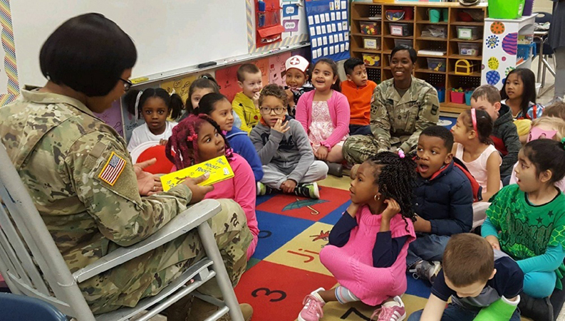 U.S. Army Master Sgt. Nekia Haywood with 80th Training Command (TC) reads to children at Hopkins Elementary School.