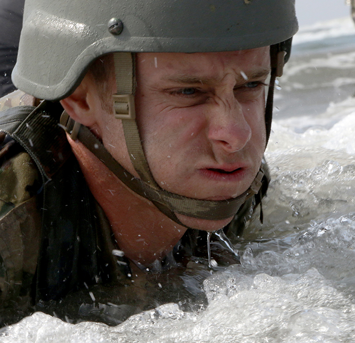 U.S. Army Spc. Roger Spain high crawls through the tide