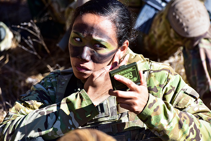A Paratrooper puts the finishing touches to her face camouflage