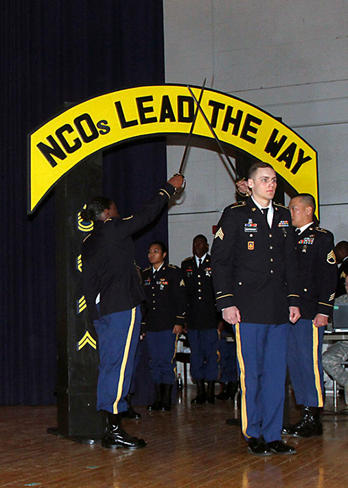 101st Airborne Division, walks through the NCO Arch during a noncommissioned officer induction ceremony