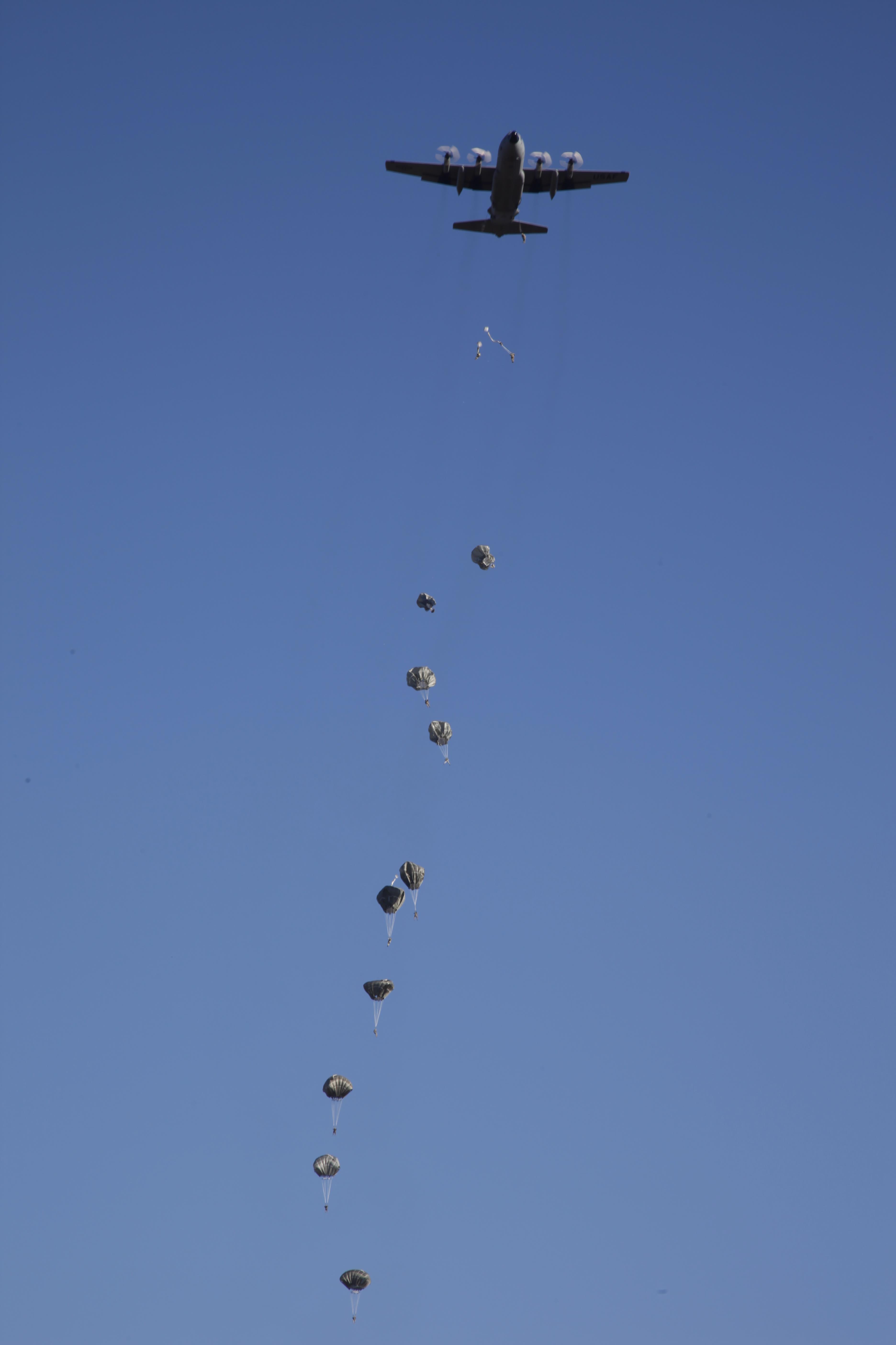U.S. Army paratroopers descend on Sicily Drop Zone from a C-130 aircraft during an airborne operation for the 18th Annual Randy Oler Memorial Operation Toy Drop
