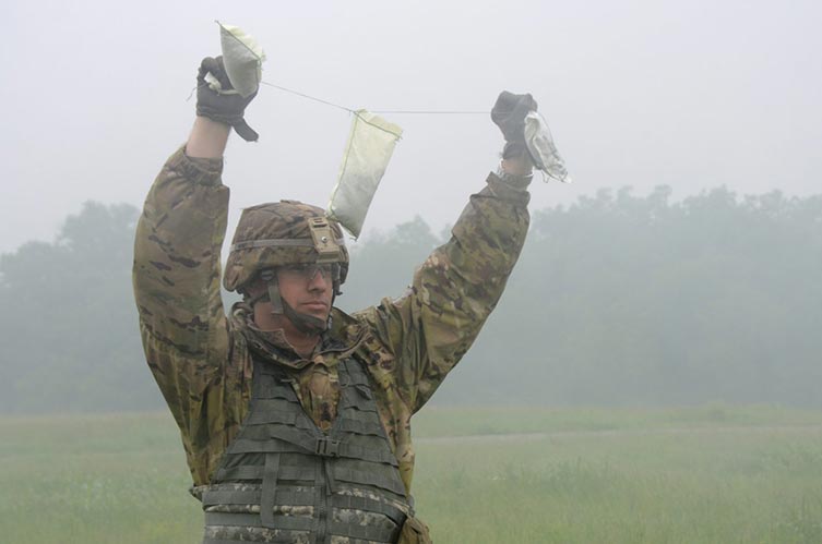 A student in the Advanced Leader Course at Fort Sill, Oklahoma, holds up the three excess gunpowder bags