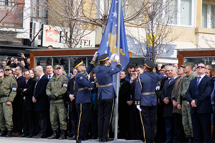 Members of the Kosovo Security Force raise the Kosovo flag