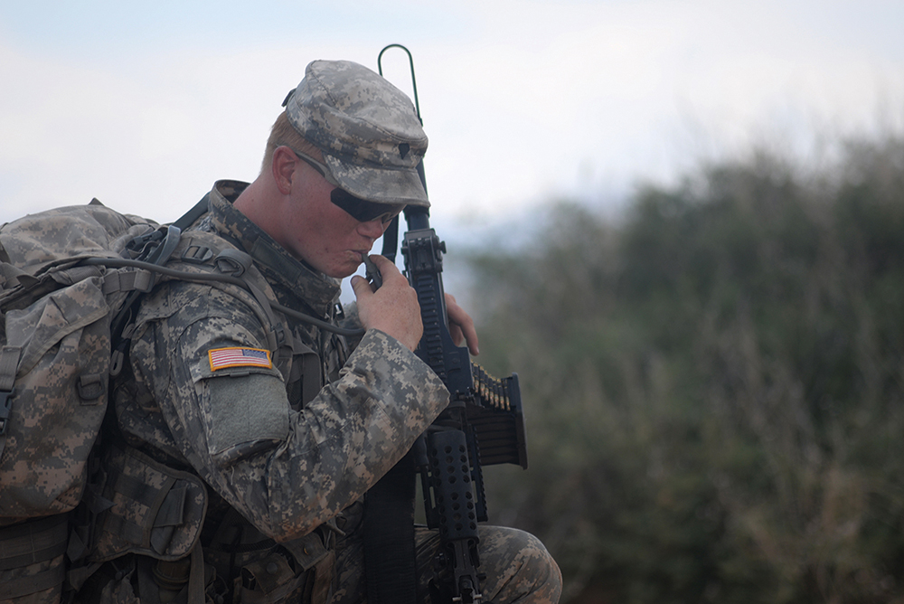 Spc. Riley Ladd of 4th Battalion, 17th Infantry Regiment, 1st Brigade Combat Team (Stryker), 1st Armored Division takes a break to drink water while on a field exercise during the new Desert Warrior course at Fort Bliss, Texas. (Photo by Meghan Portillo/NCO Journal)