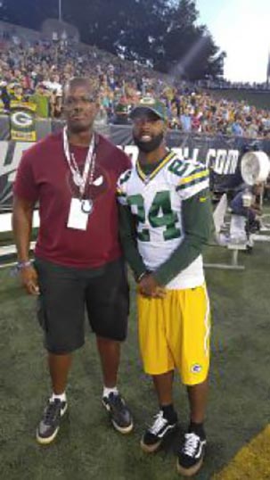 >Staff Sgt. Kyle Richardson stands with Green Bay Packers cornerback Jarrett Bush during the Pro Football League Hall of Fame Game