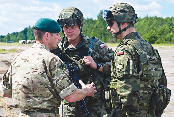 Maj. Simon Cox, commander of X-Ray Company, 45 Commando Royal Marines, talks with soldiers from 7th Air Cavalry Battalion