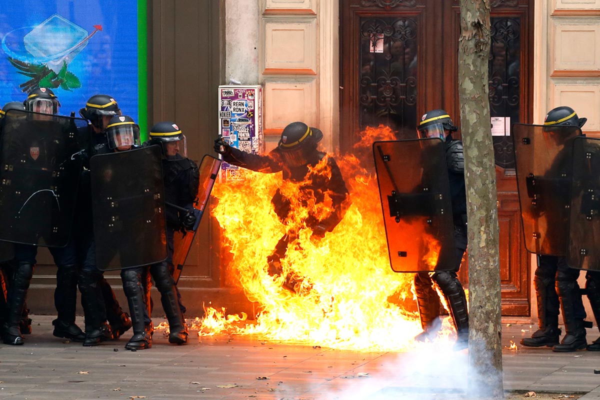 A French riot police officer is engulfed in flames after a Molotov cocktail was thrown by protestors 15 September 2016
