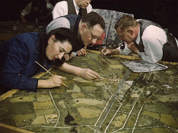 Men and women prepare for jobs in the Army or in industry in a 1943 camouflage class at New York University, New York.