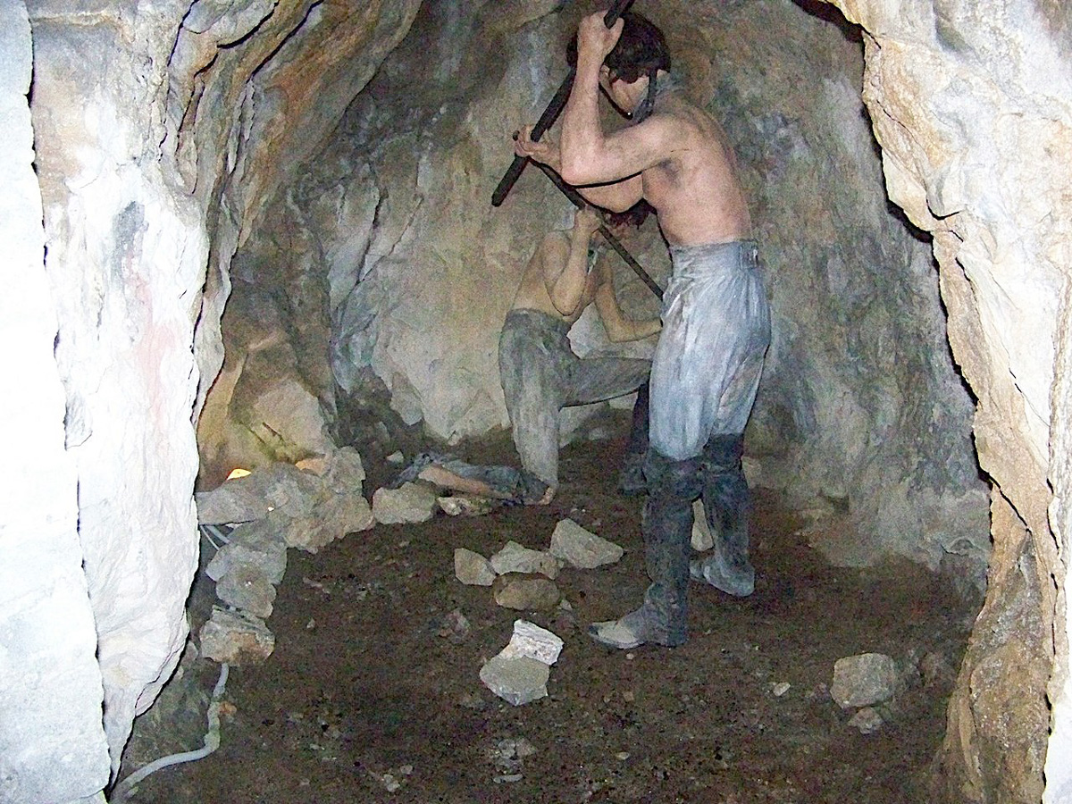 Photo of two people digging through a tunnel