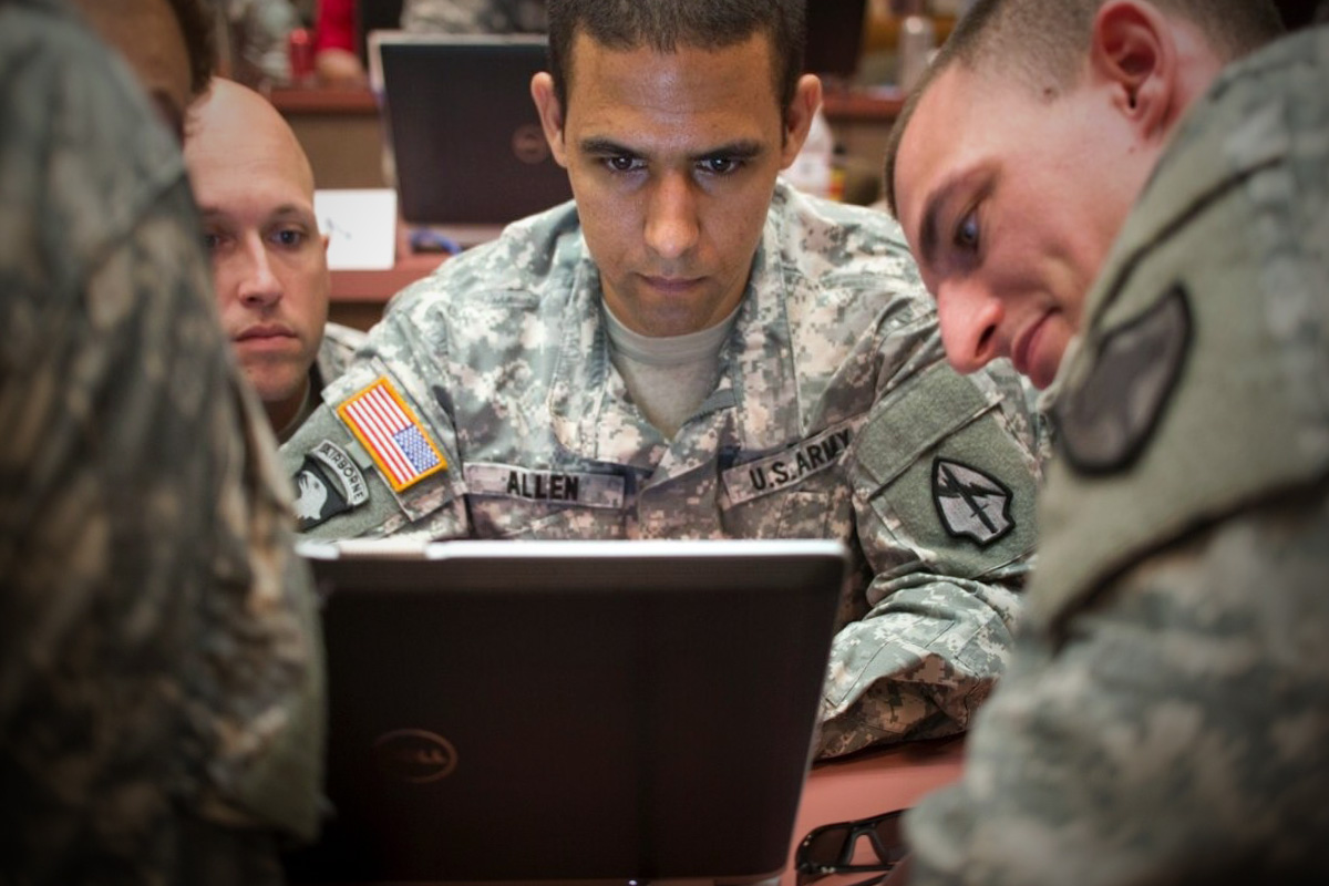 Soldiers sitting around a laptop computer