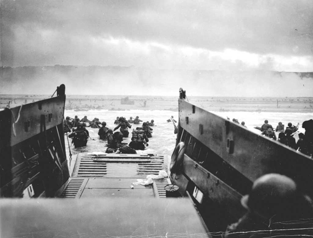 Soldiers exit a landing craft onto a smoky World War II Normandy beach, symbolizing the D-Day invasion and the beginning of Europe's liberation.