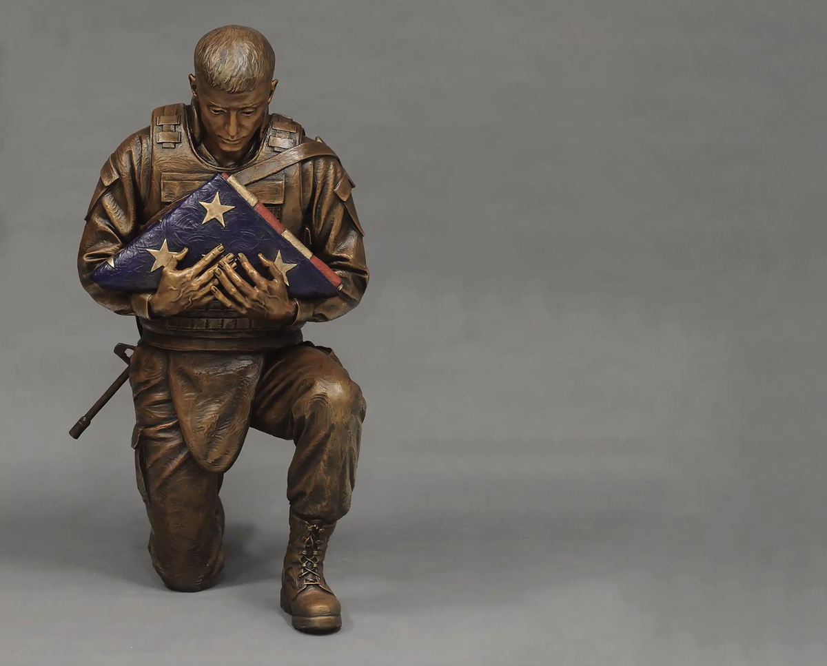 a life-size bronze sculpture that depicts a modern-day soldier holding a U.S. flag, honors the military’s fallen brothers and sisters. This sculpture was installed in May 2018 at the Fremont Veterans Memorial Park and Avenue of Flags in Fremont, Nebraska