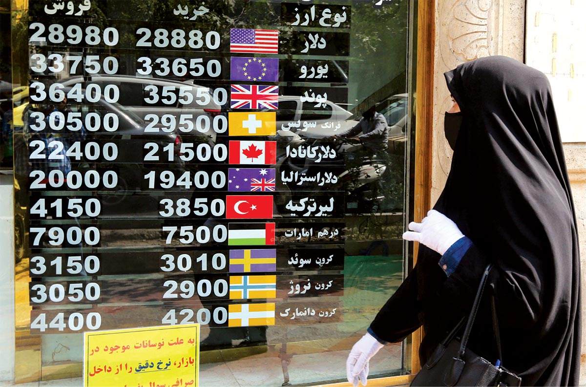 An Iranian woman checks a display board in a currency exchange shop window 29 September 2020 in Tehran, Iran.