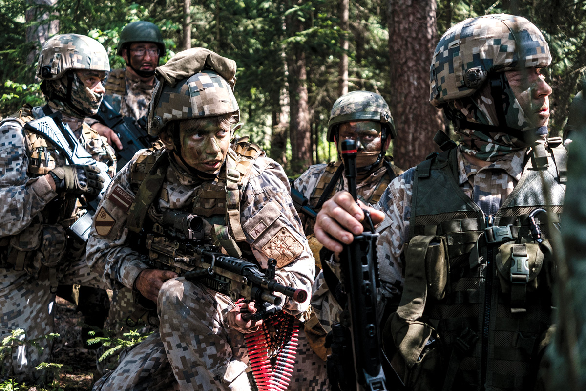 Latvian <em>Zemessardze</em>, or National Guard, soldiers prepare to attack during a small-unit tactics exercise 7 June 2020 during implementation of the Resistance Operating Concept with NATO allies and partners near Iecava, Latvia. The Zemessardze are an all-volunteer force charged with protecting the Latvian homeland. Some units are mentored by U.S. Army Special Forces soldiers. (Photo courtesy of U.S. Special Operations Command, Europe)