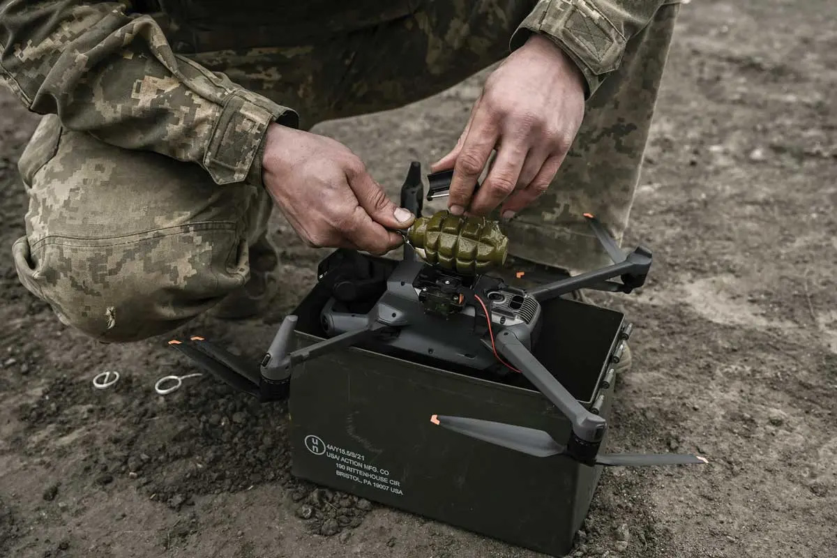 A Ukrainian serviceman attaches a hand grenade to a drone to use in an attack against Russian targets near Bakhmut in the Donbas region of Ukraine on 15 March 2023. (Photo by Aris Messinis, Agence France-Presse)