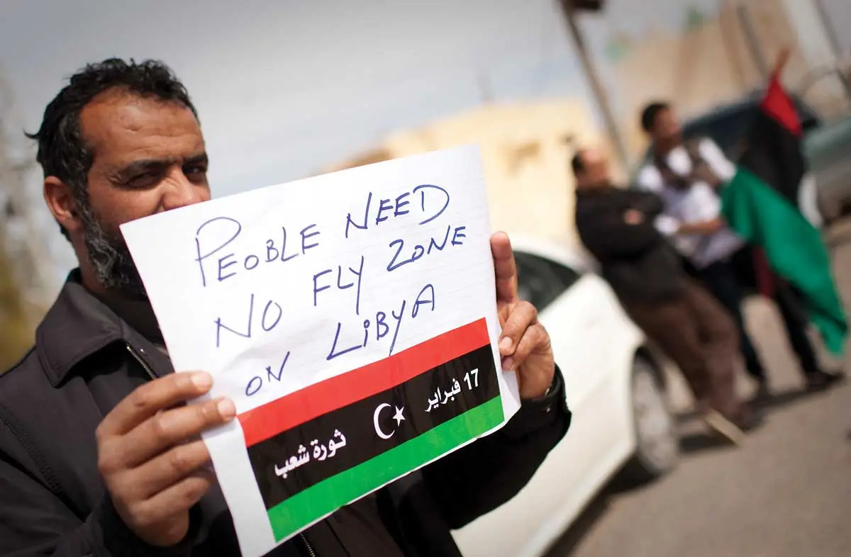A Libyan man holds up a sign