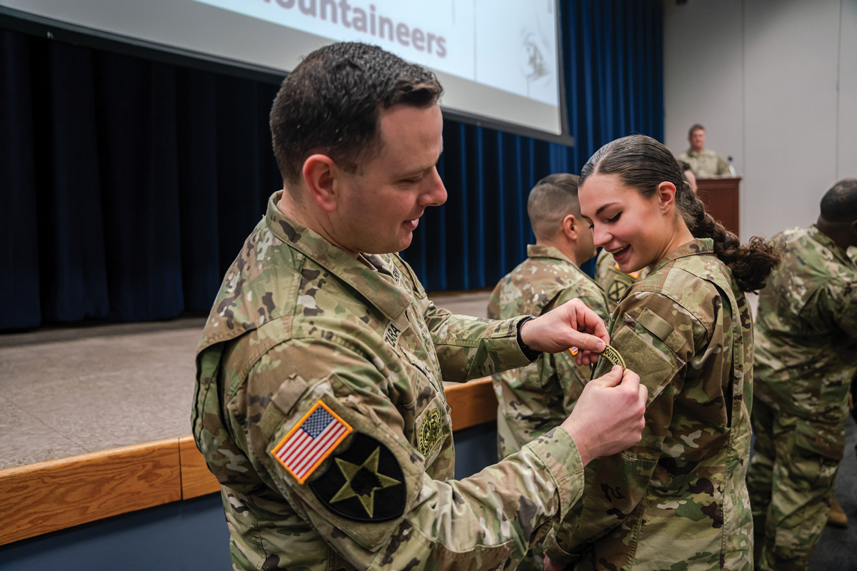 A 10th Mountain Division soldier receives her Mountain tab