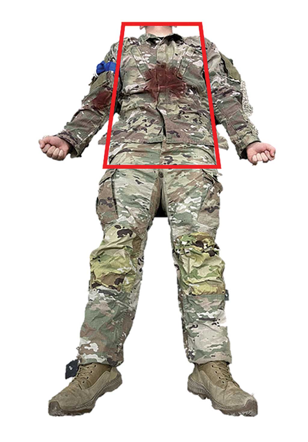 A mannequin in military uniform displays simulated torso wounds with a red trapezoid marking the target area for treatment or assessment.