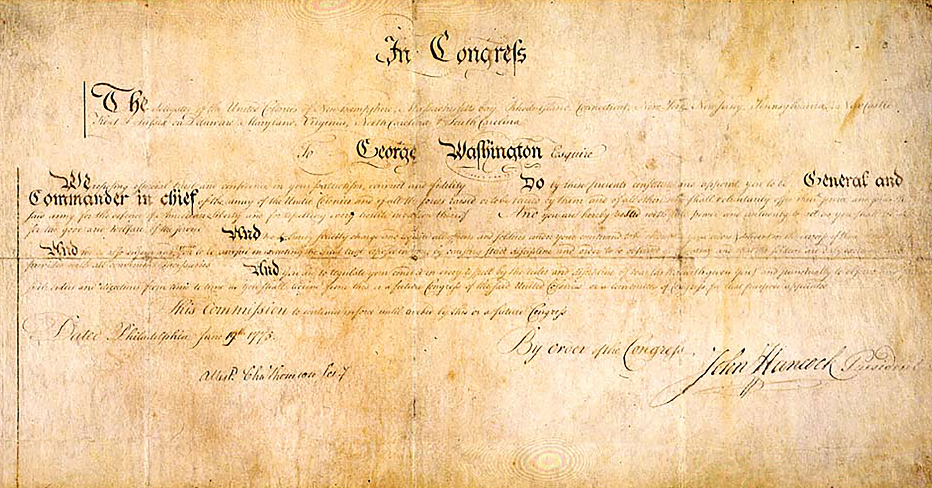 Faded parchment document appointing George Washington as Commander in Chief of the Continental Army, signed by John Hancock.