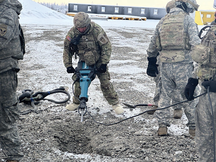 Soldiers from 2nd Battalion, 8th Field Artillery Regiment, utilizing a jackhammer to break up frozen soil in preparation for an M777A2 howitzer emplacement