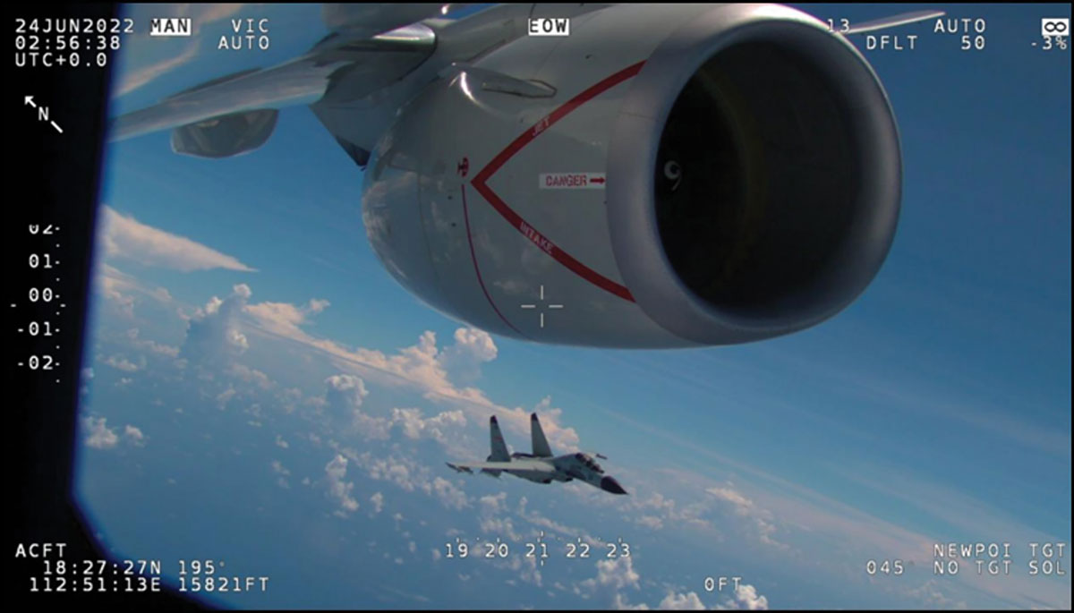 A view from an aircraft's cockpit showing another military jet flying close by, with data overlays indicating altitude, heading, and other flight parameters against a backdrop of blue sky and clouds.