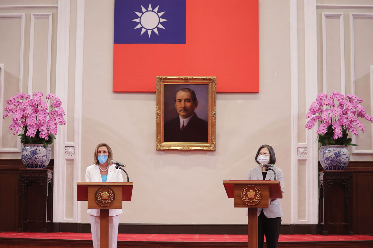 Two individuals stand at podiums with microphones, wearing masks. Behind them is the flag of Taiwan and a portrait. The scene suggests a formal event, likely a press conference or official meeting.