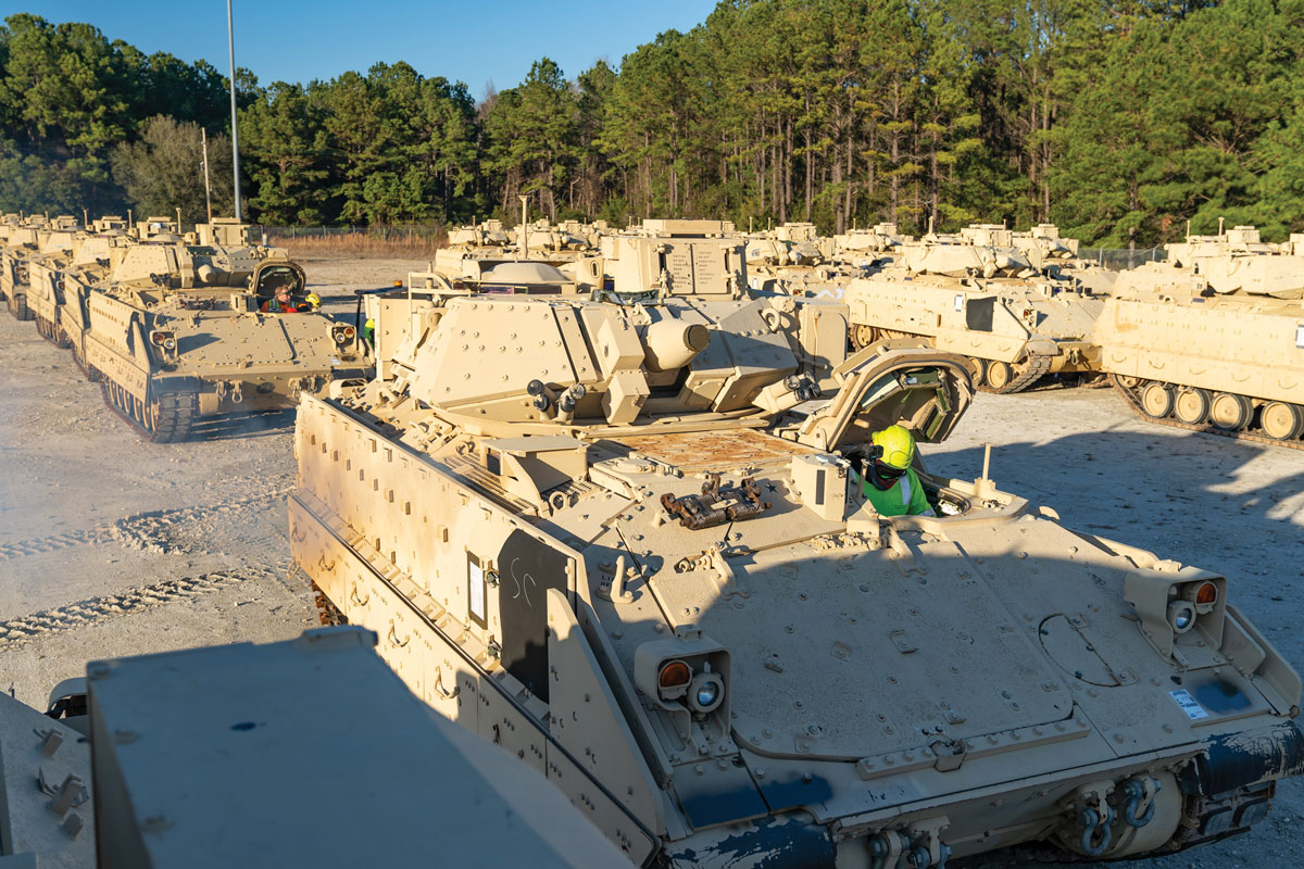 A stevedore sits in a Bradley Fighting Vehicle