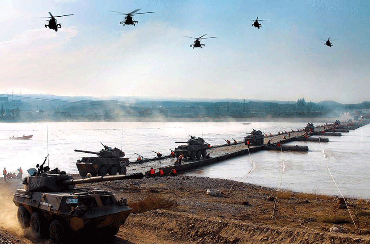 Military vehicles cross a pontoon bridge 19 October 2010
