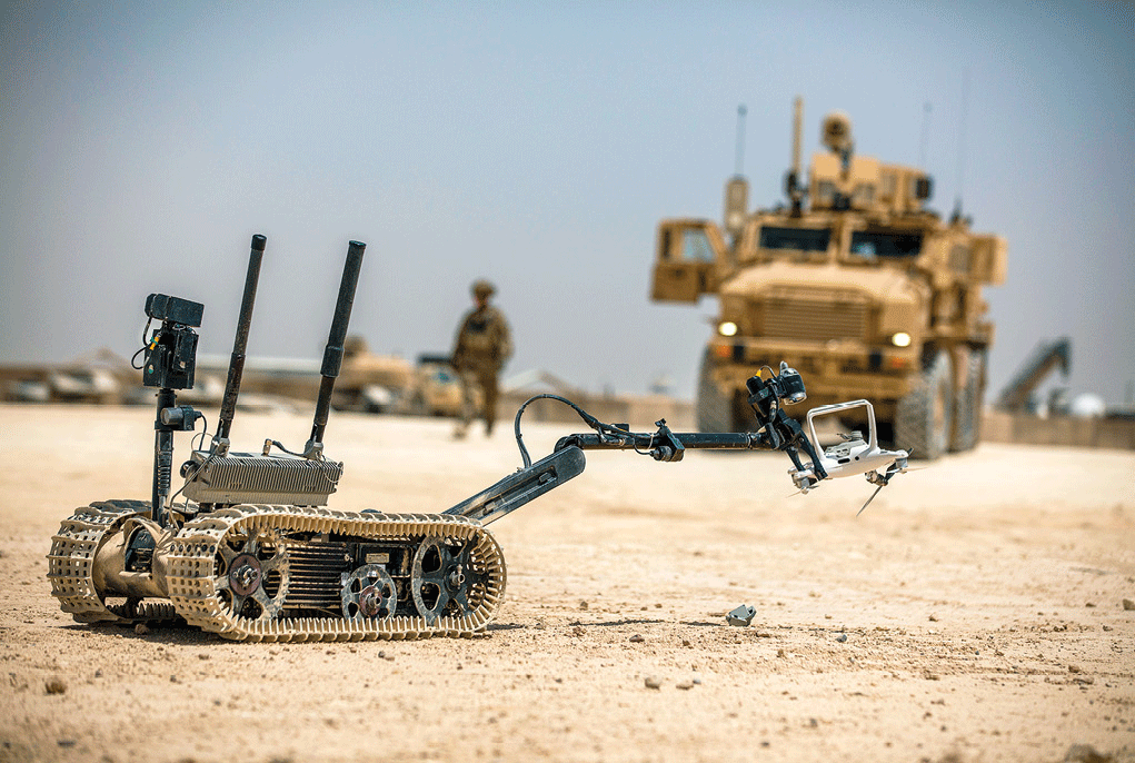 A TALON tracked military robot picks up a downed unmanned aircraft system 
