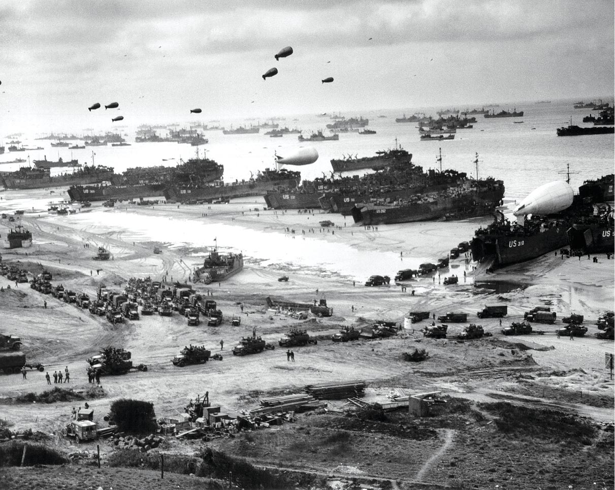A massive array of landing craft, barrage balloons, Allied troops, and equipment arrives mid-June 1944 at Omaha Beach in Normandy, France.