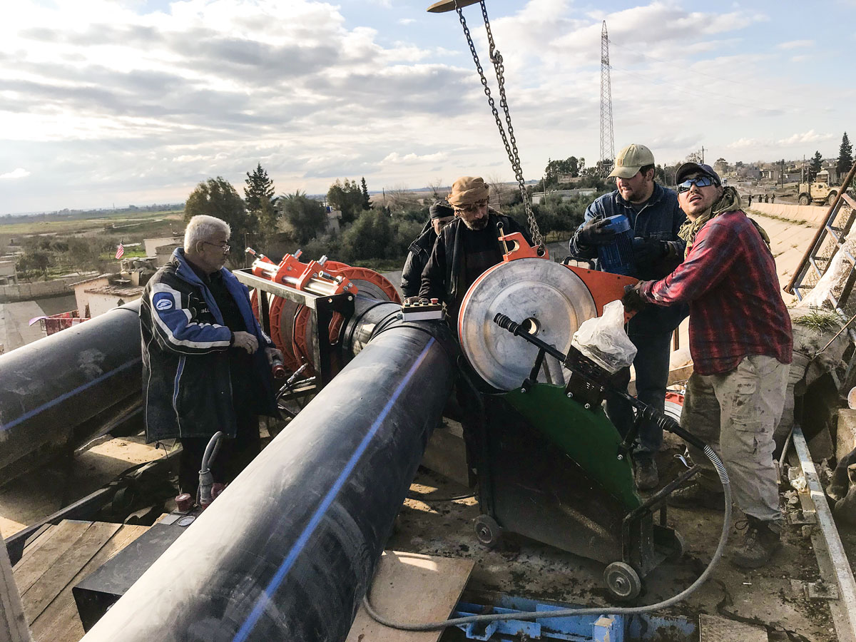 Dier-ez-Zor Civil Council engineers and U.S. Army Special Operations Command team members finish installation of discharge pipes February 2019 at Pumping Station #1 on the Euphrates River in Syria