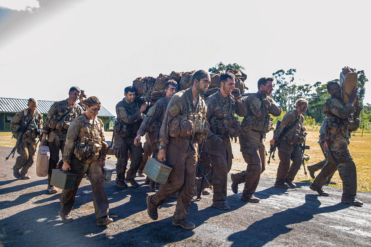 Soldiers assigned to 25th Infantry Division carry water and ammunition cans on 1 April 2021 during completion of the Green Mile, a physical endurance course that concludes training for the Jungle Operations Training Course at Lightning Academy near Schofield Barracks, Hawaii