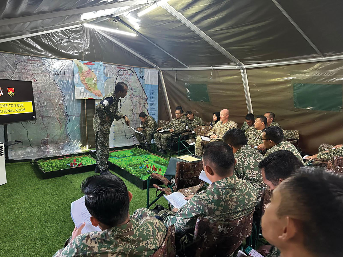 Maj. Keith M. Shively, 11th Military Police Brigade, chairs a battle update brief with Lt. Gen. Dato Tengku Fauzi, commander of the Malaysian Army Western Field Command, and staff during Keris Strike 2023, 14 July–9 August 2023, in Malaysia
