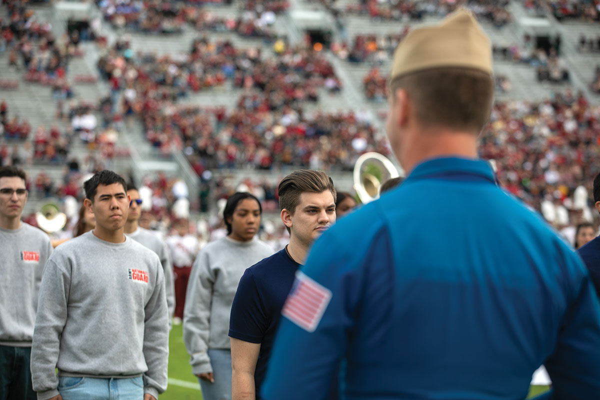 Enlistees for the Florida Army National Guard, among other branches, are sworn into the military by Cmdr. John Fay, executive officer for the U.S. Navy Blue Angels, on the football field at Florida State University’s Doak Campbell Stadium in Tallahassee prior to kickoff 22 November 2022