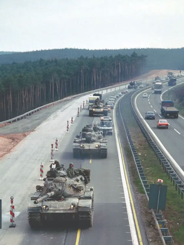 A column of 3rd Armored Division M60A3 tanks move in a convoy