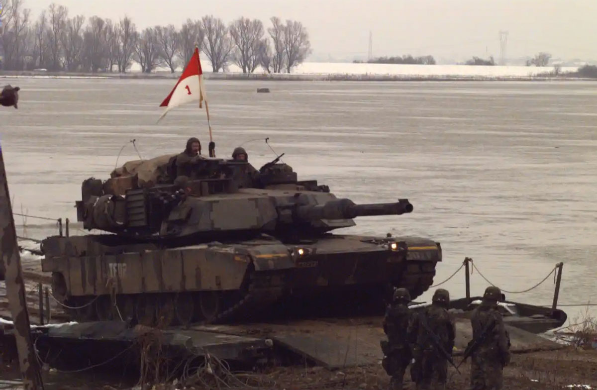 An Abrams tank of the 1st Armored Division crosses the Sava River