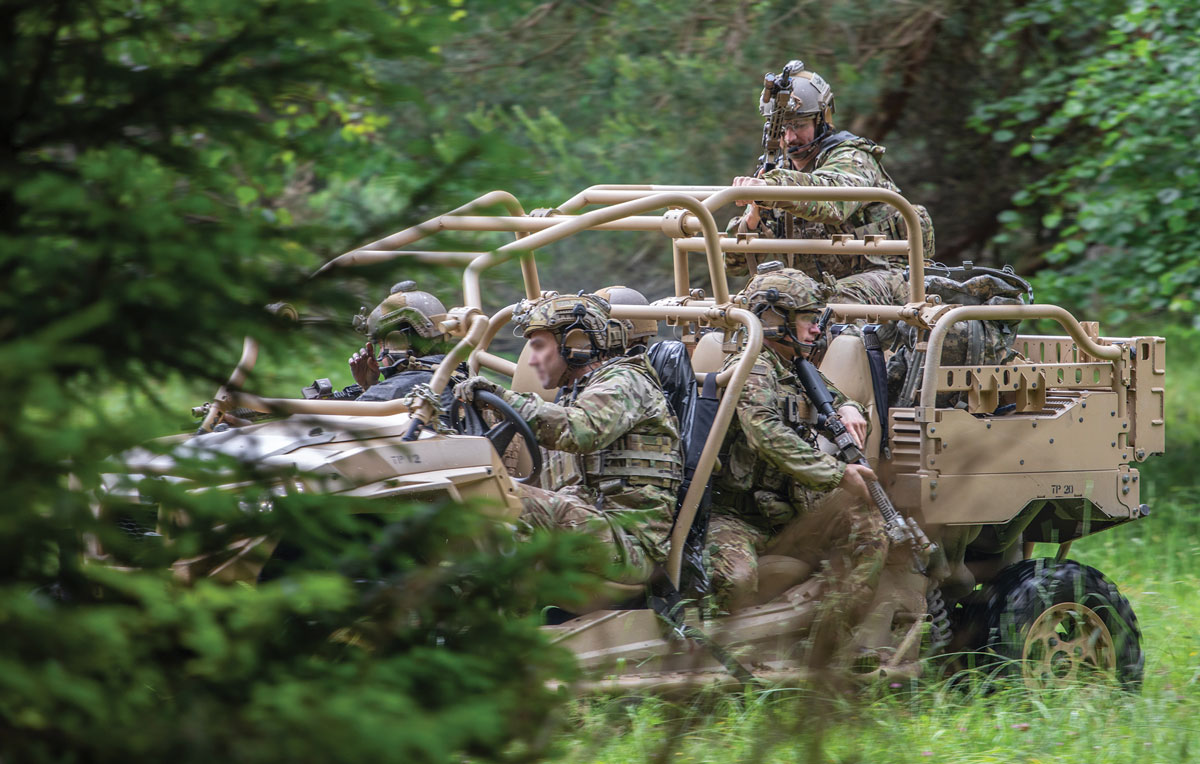 Soldiers in a camouflaged all-terrain vehicle navigate through a forested area, equipped and alert.