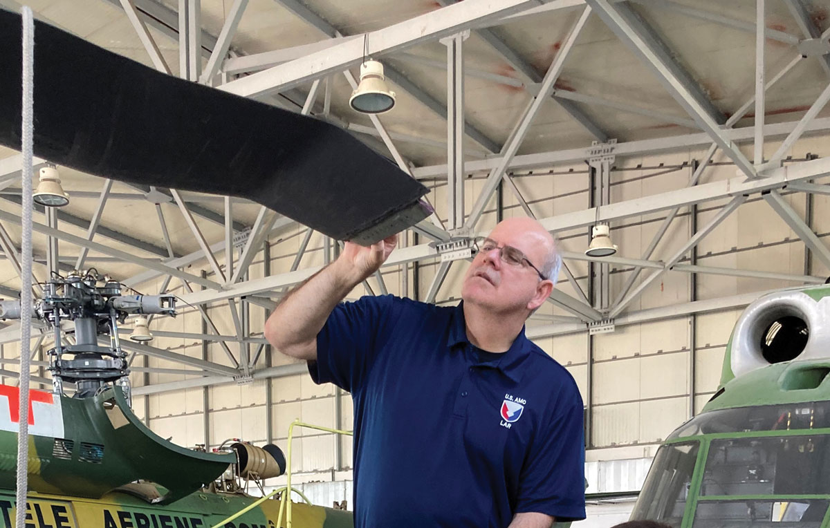 Cliff Barnes, a U.S. Army Aviation and Missile Command logistics assistance representative assigned to the 405th Army Field Support Brigade, inspects a damaged rotor blade on a UH-60 Black Hawk in a hangar 26 July 2021 at the Bucharest International Airport, Romania