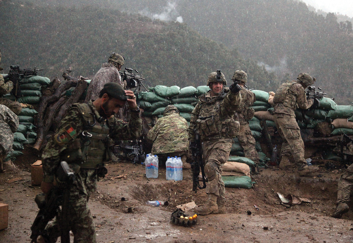 A soldier from the 2nd Battalion, 327th Infantry Regiment, 101st Airborne Division, points toward incoming fire during a firefight with the Taliban 29 March 2011 in the valley of Barawala Kalet, Kunar Province, Afghanistan