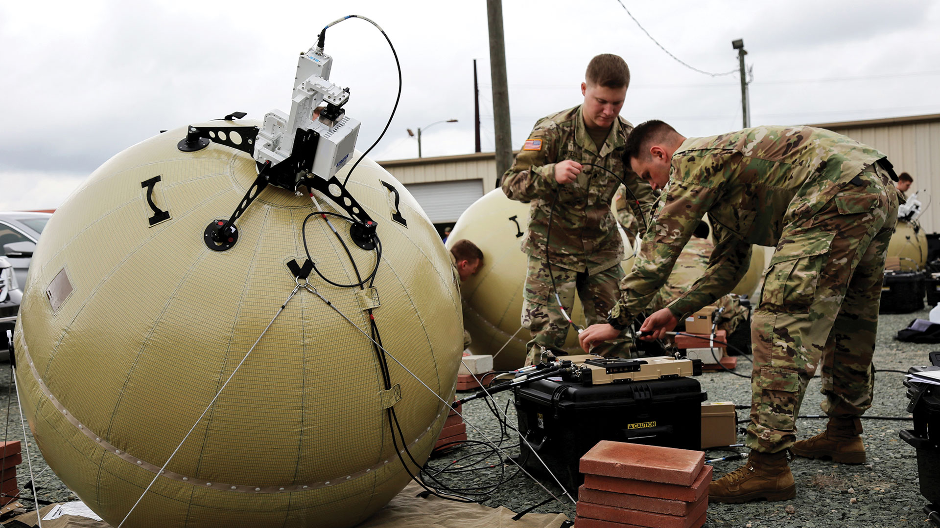 Soldiers working on an inflatable satellite system.