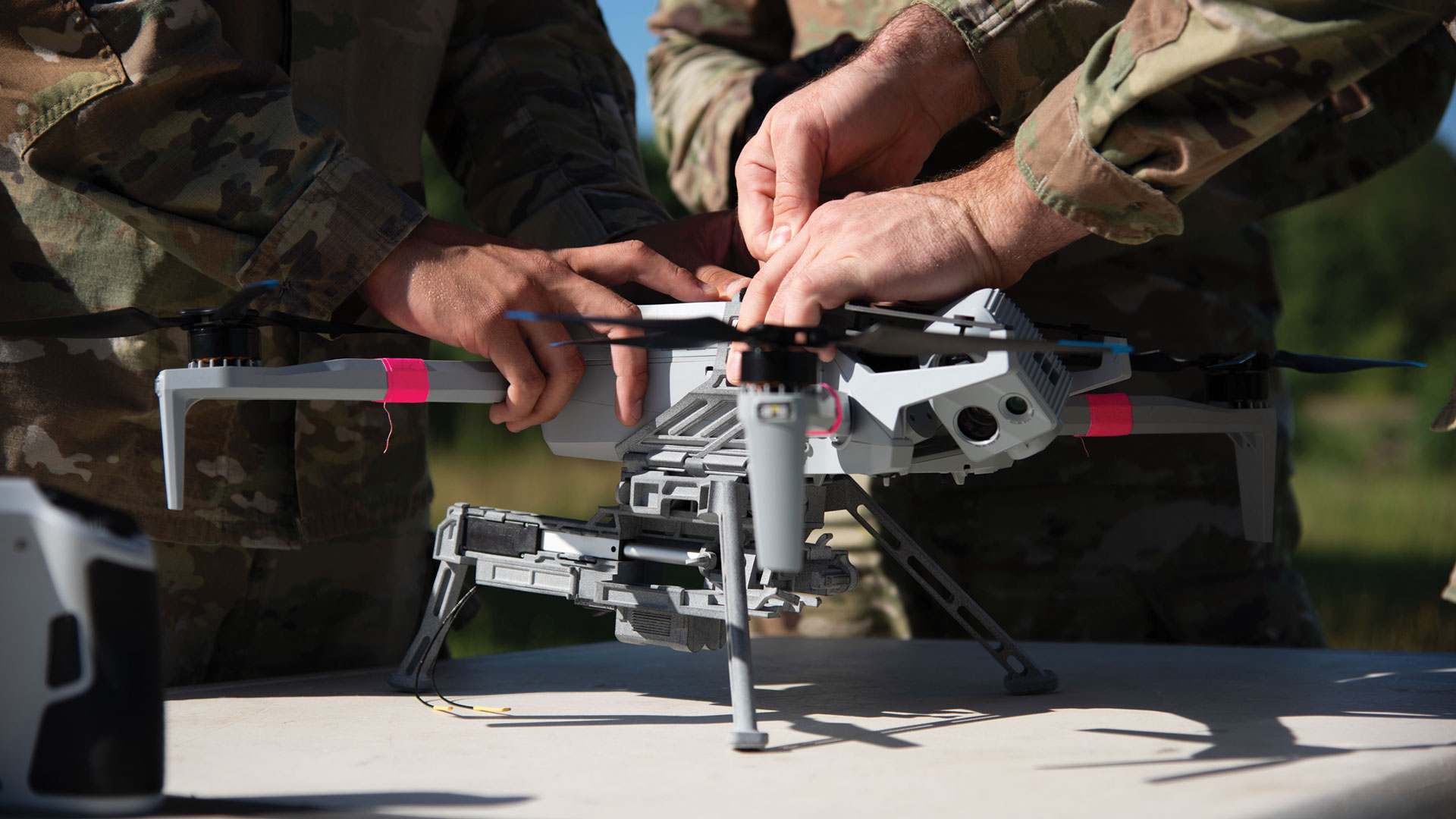 Soldiers from the 278th Armored Cavalry Regiment and 173rd Airborne Brigade work together to set up a grenade dropper on a Skydio X10 before a M67 grenade drop in the Grafenwoehr Training Area, Germany, 25 June 2025. 7th Army Training Command, Joint Multinational Training Group-Ukraine, and 173rd Airborne Brigade personnel worked together to make this the first live grenade drop from a unmanned aircraft system in the U.S. Army for conventional forces.