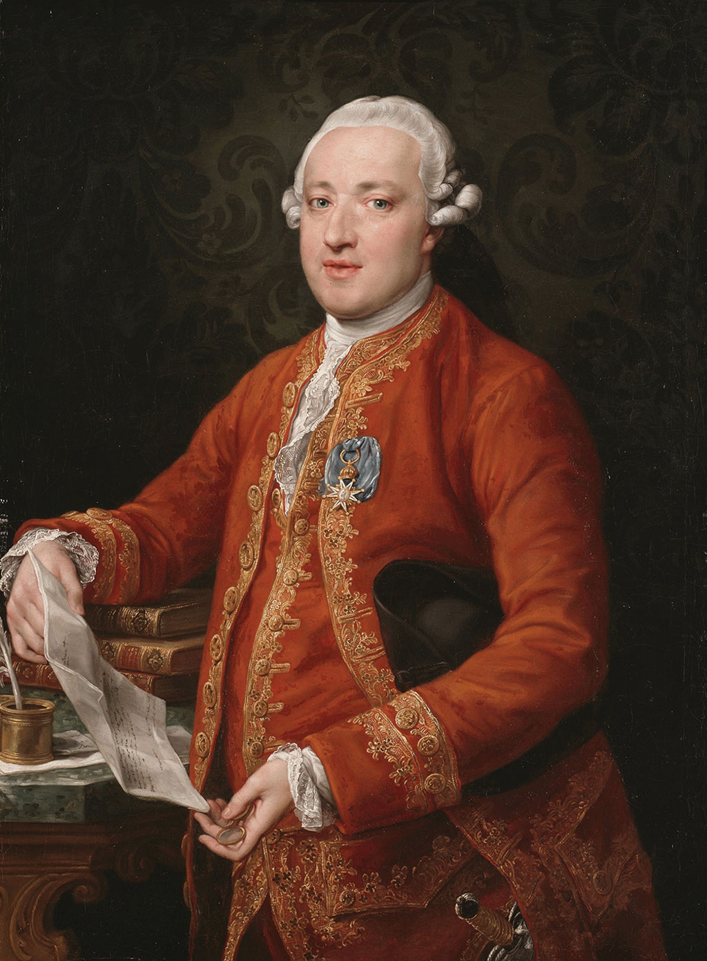 18th-century gentleman in a red embroidered coat and powdered wig holding a folded document at a desk