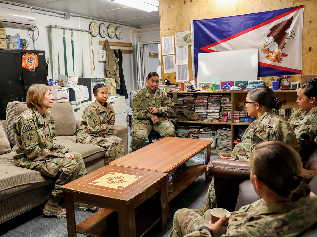 A photo a goup of soldiers sitting around a coffee table.